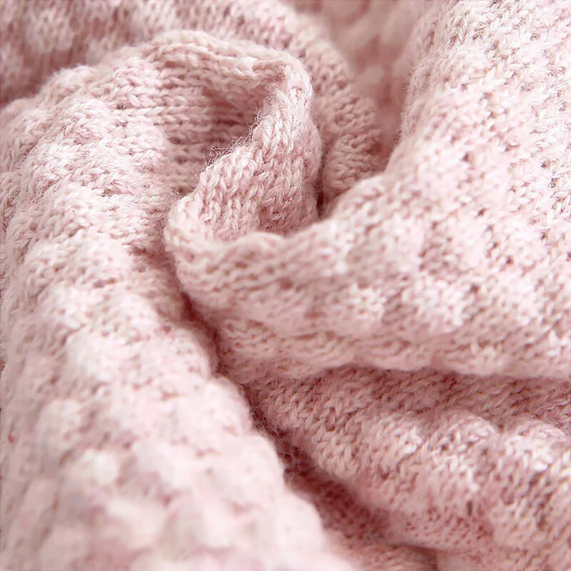 Close up of pink sweater showing knitting