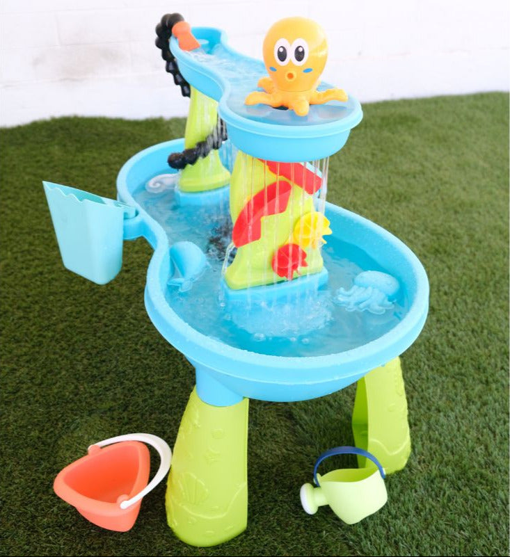 Colorful children's water play set with an octopus figure on a grassy background