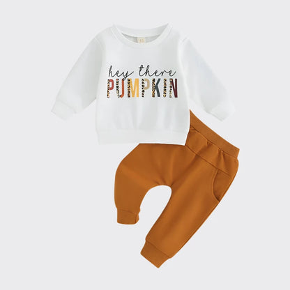 White crewneck sweatshirt with "hey there PUMPKIN" printed and orange jogger pants